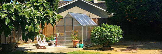 Palram-Canopia greenhouse in a blooming spring garden in Canada.